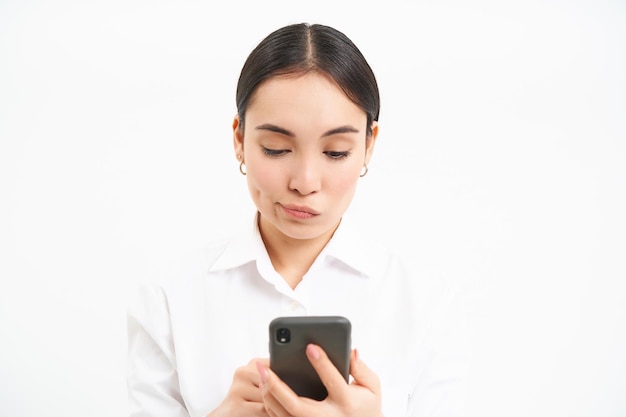 portrait korean businesswoman with worried face reading message mobile phone screen isolated o 1258 1679081