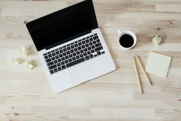 Laptop and notes on a desk for planning website pages