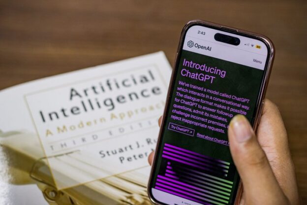 Person holding a smartphone showing the Introducing ChatGPT page