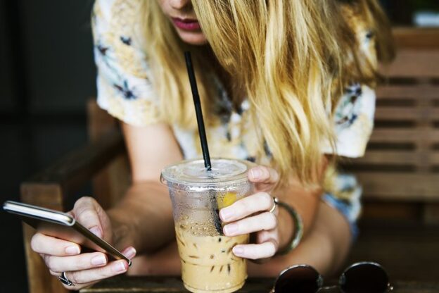 Person messaging on a smartphone at a café